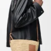 Pochette-Tasche „Slit“ aus Raffia und Kalbsleder Pochette-Tasche „Slit“ aus Raffia und Kalbsleder